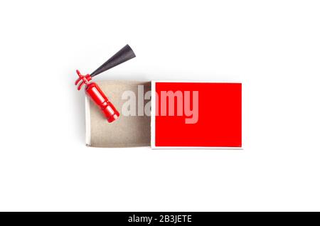 Miniature fire extinguisher inside an opened red match box, top view on white Stock Photo