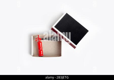 Small size fire extinguisher inside an opened match box, top view on white Stock Photo