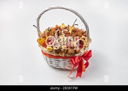 White basket full of dried fruits and exotic nuts on a white background. Stock Photo