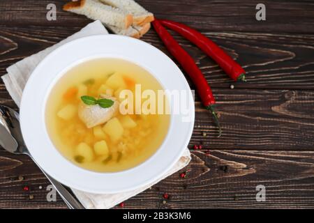 Chickpea soup on a wooden background. Near red chilli greens. Copy space Stock Photo