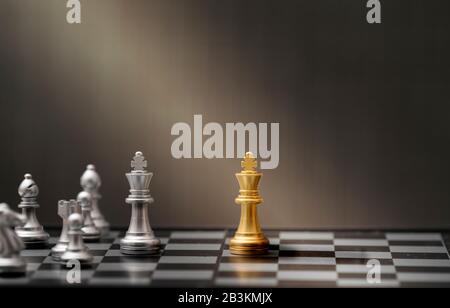 golden and silver chess pieces on dark background Stock Photo
