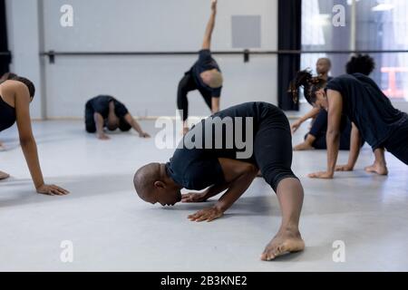 Group of modern dancers stretching up in a studio Stock Photo