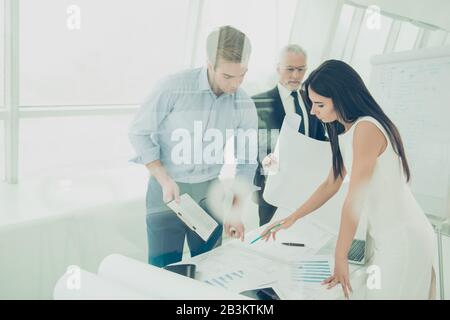 Concentrated architects working with blueprint to end project of house Stock Photo