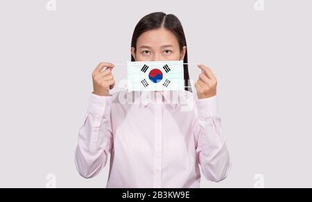 Asian woman wearing hygienic face mask painting South Korea flag to protect from the Coronavirus 2019 (COVID-19) infection outbreak situation, the vir Stock Photo