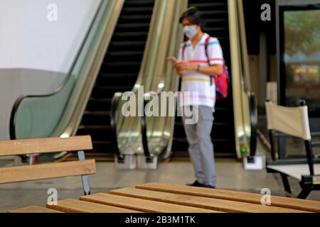 Closeup empty wooden table with blurry man wearing face mask protects against flu Stock Photo