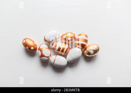A bunch of different drawing golden eggs on a white table Stock Photo