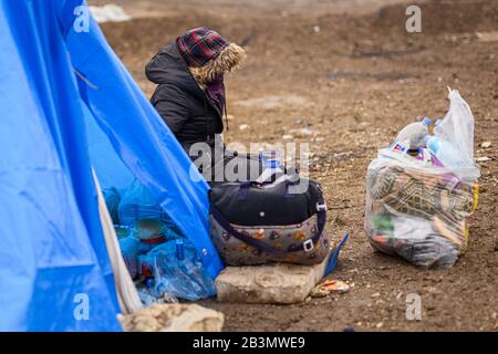 Edirne, Turkey. 05th Mar, 2020. A Syrian refugee woman sits by her tent in the Turkish border town of Edirne on the river 'Tunca Nehri' near the Pazarkule-Kastanies border crossing and has her belongings in a bag in front of her. Credit: Mohssen Assanimoghaddam/dpa/Alamy Live News Stock Photo
