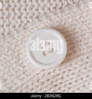 White knitted texture with a white button horizontal background Stock Photo