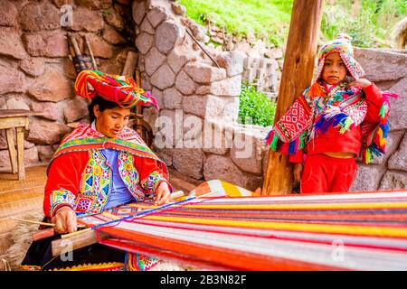 Quechua woman from the Accha Huata, Bombom, and Paucartambo communities working her loom, Sacred Valley, Peru, South America Stock Photo