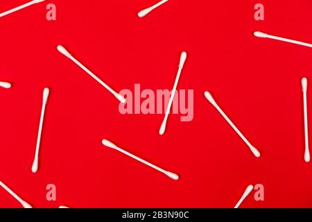 Flat lay composition with cotton swabs on red background. Top view ear sticks. Stock Photo