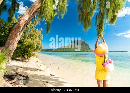 Woman having fun under a tropical tree on sandy beach, Ile aux Benitiers, La Gaulette, Le Morne Brabant, Mauritius, Indian Ocean, Africa