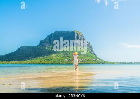 Woman admiring Le Morne mountain standing in the shallow water of turquoise lagoon, La Gaulette, Mauritius, Indian Ocean, Africa Stock Photo