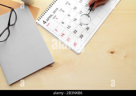 Concept image of business and meetings. Calendar to remind you an important appointment and Magnifying glass Stock Photo