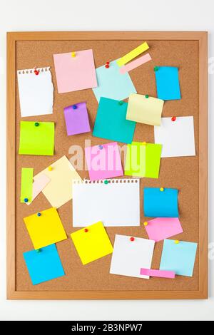 Cork board with several colorful blank notes with pins Stock Photo