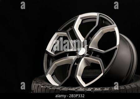 aluminum alloy wheel. Premium cast, the design of the spokes and the wheel rim, a white and black elements on dark background close-up. Stock Photo