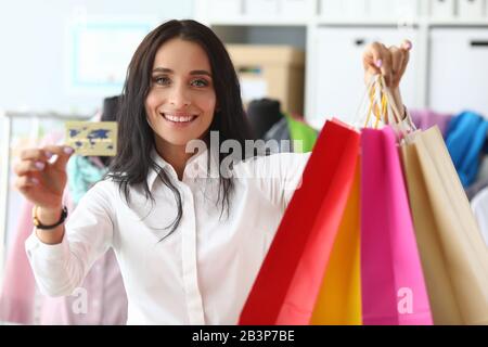 Stylish woman shows credit card and packages Stock Photo