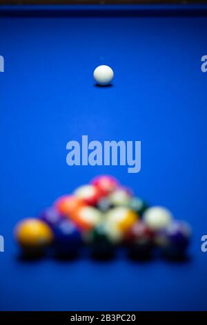 Colorful balls on a blue pool table. Set up and ready to play. Selective focus. Stock Photo