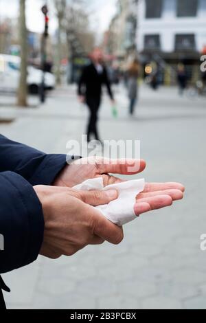 closeup of a caucasian man on the street disinfecting his hands with a wet wipe Stock Photo