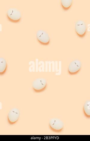 Happy Easter. White eggs with painted eyes on yellow background. Vertical picture. Stock Photo