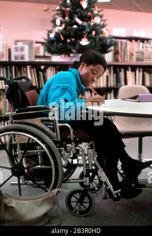 Austin, Texas USA, circa 1993: Disabled Nigerian student does research in library. MR ©Bob Daemmrich Stock Photo