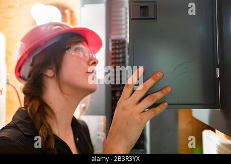 close up on construction inspector woman inspect house electrical systems, inspecting a modern eco energy efficient home. check the Distribution board Stock Photo