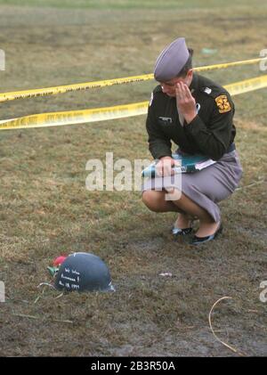 College Station, Texas USA, 20NOV99: A female member of the Texas A&M University Corps of Cadets weeps at the sight of a protective helmet (POT) of a student killed in the collapse of the Texas A&M bonfire last Thursday. Thousands of people paid their respects to the dead over the weekend. ©Bob Daemmrich Stock Photo