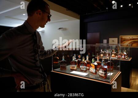 Man looking at the collection of Woodford Reserve & the Kentucky Derby special edition Bourbon Whiskey in the Frazier History Museum.Louisville.Kentuc Stock Photo