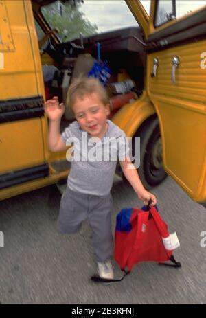 Austin Texas USA: Young hearing-impaired special education public school student waves goodbye to his bus driver as he steps off school bus.  ©Bob Daemmrich Stock Photo