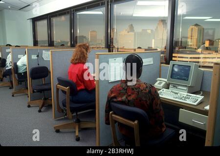 Austin Texas USA: Telemarketers use headsets to make calls from cubicles at credit card sales center. Bob Daemmrich Stock Photo