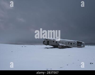 A stripped-down plane wreck in the snow photographed from the side Stock Photo