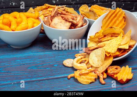 Differnt Types of Junk food, salty-sticks, salty-crackers on wooden table in still-life Stock Photo