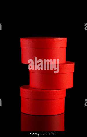 stand on each other three red gift boxes on black background, isolated Stock Photo