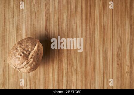Walnuts kernels on dark desk with color background, Whole walnut in wood vintage bowl Stock Photo