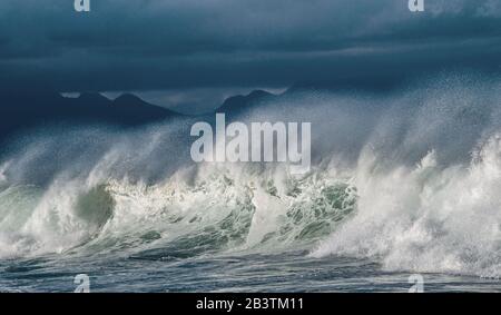 Seascape. Powerful ocean wave on the surface of the ocean. Wave breaks on a shallow bank. Stormy weather, stormy clouds sky background. Stock Photo