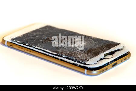 Modern smartphone with highly broken screen isolated on white background. Stock Photo