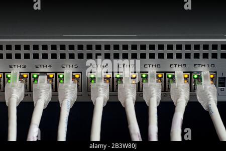 White network cables connected to a switch. Selective focus Stock Photo