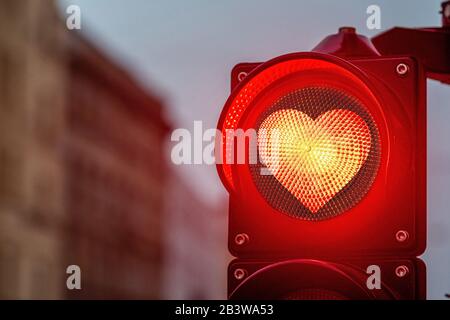 A city crossing with a semaphore,  traffic light with red heart-shape in semaphore - image Stock Photo