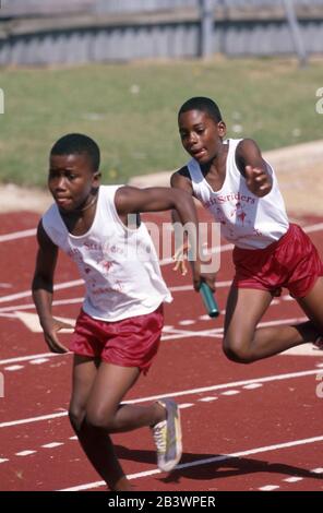 Austin, Texas USA:  Relay handoff in youth Amateur Athletic Union (AAU) summer track meet. ©Bob Daemmrich Stock Photo