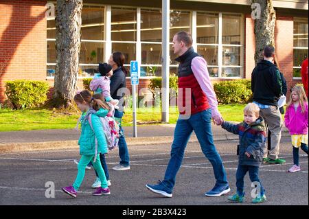 Parents walk their children to school as Lake Oswego, Oregon school officials reopen the Forest Hills Elementary School after being closed since last Friday due to a positive COVID-19 test on a school employee. The school district brought in a specialized cleaning team that worked through the weekend. A cleaning of Lake Oswego schools is estimated at $100,000.00. Stock Photo