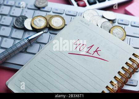 401k text on notepad with coins and keyboard on table  Stock Photo