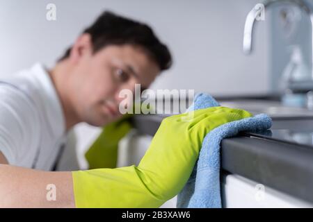 Young Cleaner Man Wearing Apron Cleaning Dirty Kitchen Worktop Stock Photo