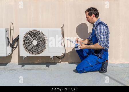 Man Doing Heating, Ventilation, And Air Conditioning Inspection Stock Photo