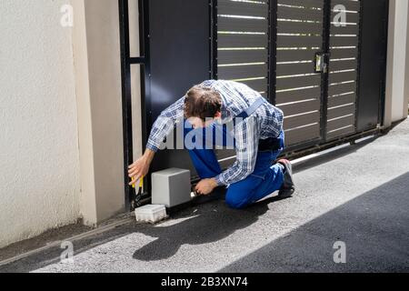 Repairman Fixing Broken Automatic Door In Building Stock Photo