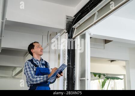 Portrait Of Male Male Electrician Installing Cables Stock Photo