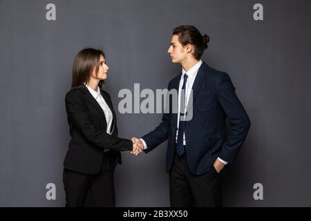 Man and woman business handshake isolated on gray background. Businessman and business woman handshake close up Stock Photo