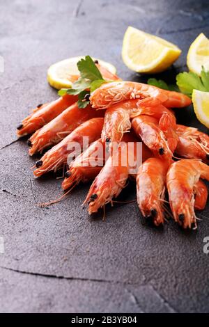 Raw fresh Prawns Langostino Austral. shrimp seafood with lemon and spices on table Stock Photo
