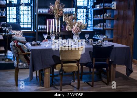 London, UK - 23 February 2020, The interior of the Liberty store on Regent Street. A large table with a white tablecloth is served with china, with hy Stock Photo