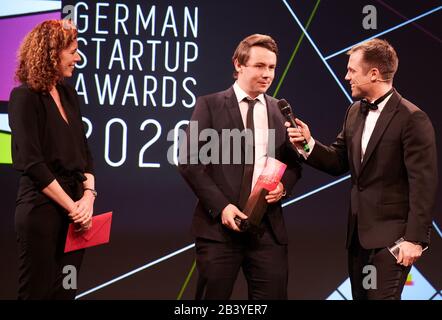 Berlin, Germany. 05th Mar, 2020. Christian Piechnick (M), CEO and founder of Wandelbots GmbH, receives the German Startup Award in the category 'Best Newcomer'. Next to him are laudator Miriam Wohlfarth, CEO and co-founder of RatePAY, and presenter Ole Tillmann. The Startup Awards are presented in nine categories to outstanding personalities of the German startup ecosystem. Credit: Annette Riedl/dpa/Alamy Live News Stock Photo
