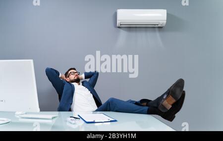 Relaxed Businessman Enjoying The Cooling Of Air Conditioner In The Office Stock Photo
