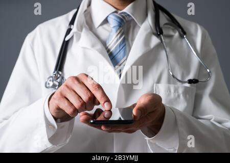 Close-up Of A Doctor's Hand Using Smartphone In Clinic Stock Photo